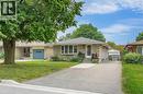 Stone facade bungalow with a single-car driveway, mature front yard tree, and an exterior side entrance - 111 Kimberly Crescent, Kitchener, ON  - Outdoor With Facade 
