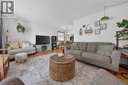 Spacious living area featuring light-colored walls and wood-finish flooring - 