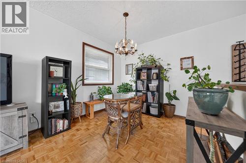 Dining area featuring wood-finish parquet flooring, a chandelier light fixture, and a window with a wood frame - 111 Kimberly Crescent, Kitchener, ON - Indoor Photo Showing Dining Room