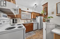 Kitchen featuring wood-finish cabinetry, light-toned countertops, and a tile backsplash - 