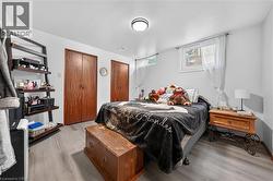 Interior space featuring wood-finish flooring, white walls, and a flush-mount ceiling light - 