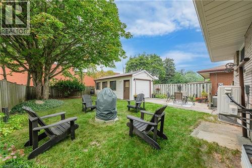 Expansive backyard featuring a mature tree, manicured lawn, and a detached garage with a white overhead door - 111 Kimberly Crescent, Kitchener, ON - Outdoor