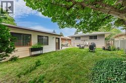 Expansive yard featuring a manicured lawn, established landscaping, and mature trees providing natural shade - 