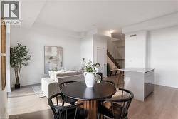 Bright open-concept interior featuring light wood-finish flooring, white walls, and recessed lighting - 