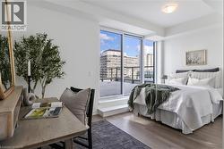 Bedroom featuring floor-to-ceiling sliding glass doors, light wood-finish flooring, and a flush mount ceiling light - 