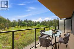 Balcony featuring a glass railing, concrete flooring, and a frosted privacy screen - 