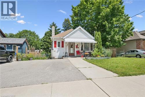 White clapboard exterior featuring red window shutters and a striped awning - 95 Forest Road, Cambridge, ON - Outdoor