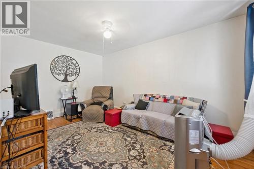 Living area featuring wood-finish flooring, white walls, and a ceiling-mounted light fixture - 95 Forest Road, Cambridge, ON - Indoor