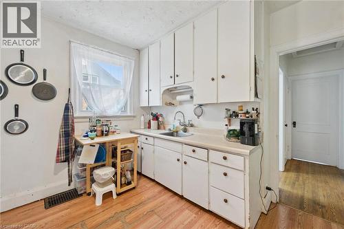Kitchen featuring white cabinetry, light-toned countertops, and wood-finish flooring - 95 Forest Road, Cambridge, ON - Indoor Photo Showing Kitchen