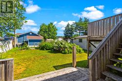 Rear deck overlooking the mature backyard and gardens. - 