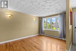 Bright living room filled with natural light and hardwood flooring. - 