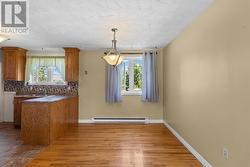 Bright dining room with hardwood flooring. - 