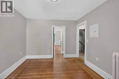 Interior room featuring wood-finish flooring, light grey walls, white trim, and a flush-mount ceiling light - 103 Mary Street, Hamilton, ON - Indoor Photo Showing Other Room