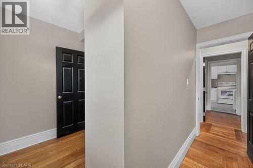 Herringbone wood-finish flooring complements the neutral wall color and white baseboards - 103 Mary Street, Hamilton, ON - Indoor Photo Showing Other Room