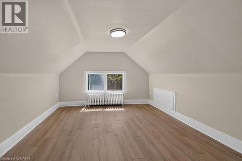 Attic space featuring wood-finish flooring, white baseboards, and a window providing natural light - 103 Mary Street, Hamilton, ON - Indoor Photo Showing Other Room