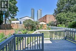 Spacious outdoor deck with painted wood railing overlooking a verdant yard - 
