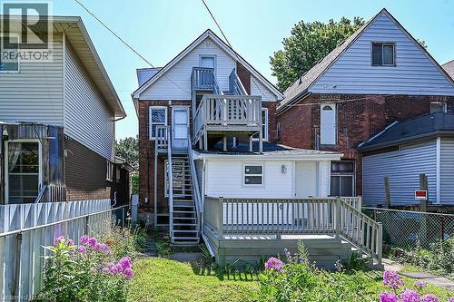 Rear exterior featuring a brick facade with light-colored siding accents - 103 Mary Street, Hamilton, ON - Outdoor