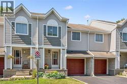 Multi-level townhome exterior featuring light gray horizontal siding and dark gray shake accents - 