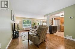Open concept living space featuring wood-finish flooring, a bright window, and neutral wall tones - 