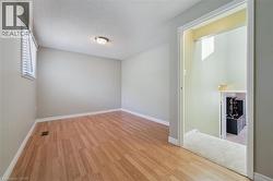 Room featuring wood-finish flooring, neutral wall paint, and a window with horizontal blinds - 