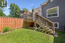Elevated wood deck with stairs descending to a grassy yard - 
