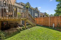 Expansive backyard featuring a wood privacy fence, a multi-level wood deck with stairs, and a verdant lawn - 