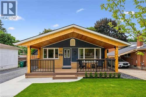Ranch-style exterior with yellow brick and dark blue siding - 223 Carter Avenue, Waterloo, ON - Outdoor With Deck Patio Veranda