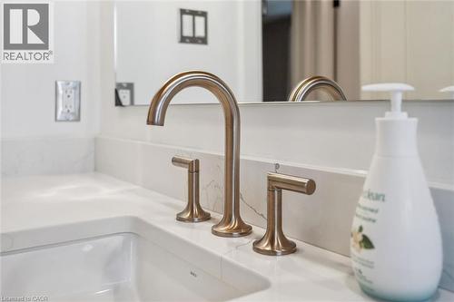White countertop featuring an integrated sink with a bronze-finish widespread faucet - 223 Carter Avenue, Waterloo, ON - Indoor Photo Showing Bathroom