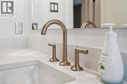 White countertop featuring an integrated sink with a bronze-finish widespread faucet - 