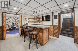 Built-in bar with a stone-finish countertop and wood-paneled base - 