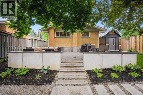 Tiered backyard patio featuring concrete steps, integrated garden beds, and a contemporary storage shed - 223 Carter Avenue, Waterloo, ON - Outdoor