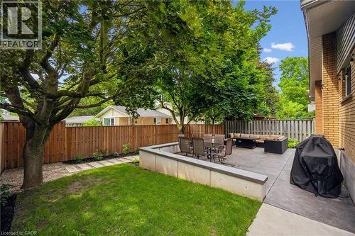 Private backyard featuring a concrete patio, retaining wall, and a wood privacy fence - 223 Carter Avenue, Waterloo, ON - Outdoor With Backyard