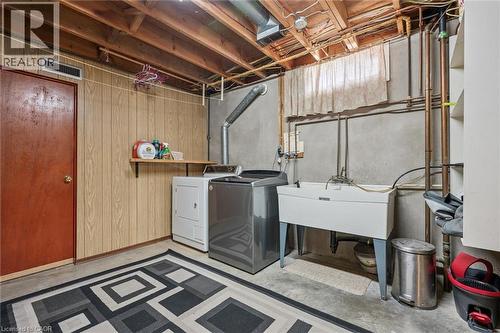 Laundry area featuring an exposed beam ceiling, wood-finish paneling, and concrete walls - 223 Carter Avenue, Waterloo, ON - Indoor