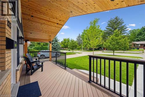 Spacious covered porch with composite decking, black metal railings, and a natural wood ceiling - 223 Carter Avenue, Waterloo, ON - Outdoor With Deck Patio Veranda With Exterior
