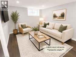 Spacious living area featuring recessed lighting, dark wood-finish flooring, a neutral color palette, and a window providing natural light - 