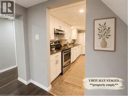 Kitchen featuring white cabinetry, stainless steel appliances, and a tile floor - 