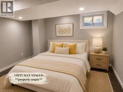 Recessed ceiling lighting illuminates this room, featuring light gray walls, dark wood-finish flooring, and white baseboards - 