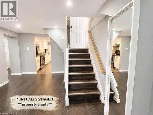 Staircase with wood-finish treads and risers, featuring a light wood handrail - 90 Arlington Boulevard, Kitchener, ON - Indoor Photo Showing Other Room