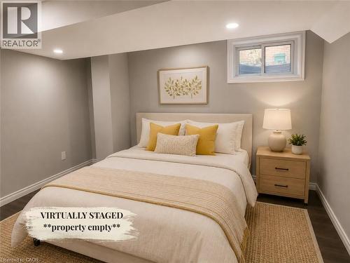 Recessed ceiling lighting illuminates this room, featuring light gray walls, dark wood-finish flooring, and white baseboards - 90 Arlington Boulevard, Kitchener, ON - Indoor Photo Showing Bedroom