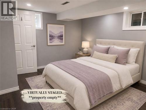 Room featuring dark wood-finish flooring, light gray painted walls, and white trim - 90 Arlington Boulevard, Kitchener, ON - Indoor Photo Showing Bedroom