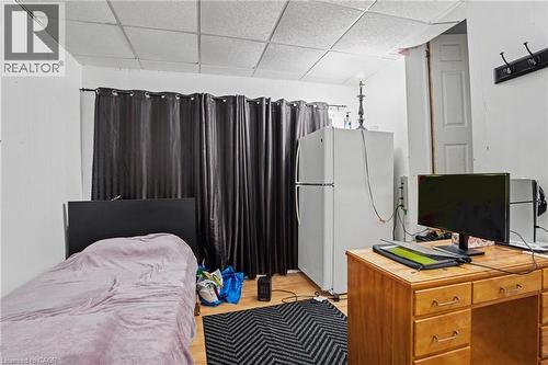 Room featuring paneling on walls, wood-finish flooring, and a grid panel ceiling - 47 Bowman Street, Hamilton, ON - Indoor Photo Showing Bedroom
