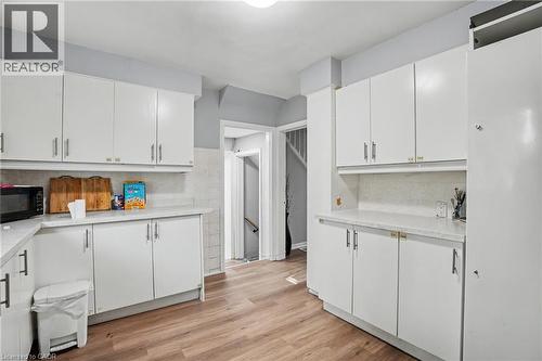 Kitchen featuring white cabinetry with silver hardware, light-toned countertops, and wood-finish flooring - 47 Bowman Street, Hamilton, ON - Indoor Photo Showing Kitchen