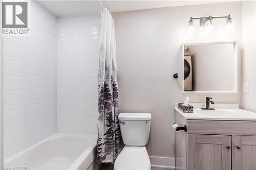 Bathroom featuring a white subway tile shower surround with horizontal texture, a white bathtub, and a vanity with a light wood-finish cabinet - 16 Ronaldshay Avenue, Hamilton, ON - Indoor Photo Showing Bathroom