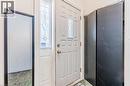 Entryway featuring a white door with decorative glass inserts, a coordinating sidelight, and a built-in closet with dark bifold doors - 16 Ronaldshay Avenue, Hamilton, ON  - Indoor Photo Showing Other Room 