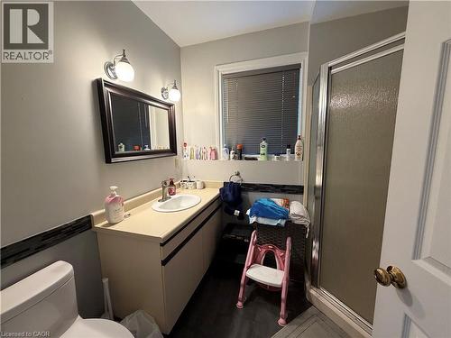 Bathroom featuring a single vanity with an integrated sink, framed mirror, and a glass-enclosed shower - 436 Gatestone Boulevard, Waterloo, ON - Indoor Photo Showing Bathroom