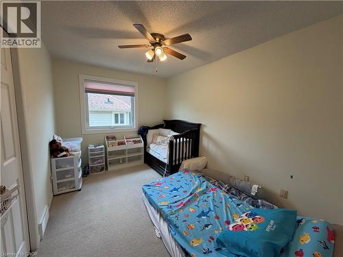 Neutral-toned room featuring a single window with a privacy blind, carpeted flooring, and a ceiling fan with integrated lighting - 436 Gatestone Boulevard, Waterloo, ON - Indoor Photo Showing Bedroom