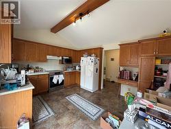 Kitchen featuring wood cabinetry, light countertops, and tile flooring - 