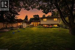 Expansive green lawn with mature trees and privacy fencing - 