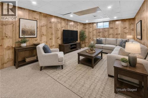 Recessed lighting illuminates the room, featuring wood-panel walls and light-toned carpeting throughout - 3 Orchard Parkway, Grimsby, ON - Indoor Photo Showing Basement