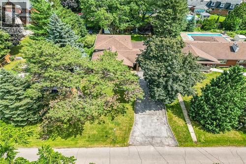 Property featuring a paved driveway, mature trees, and a shingled roofline - 3 Orchard Parkway, Grimsby, ON - Outdoor